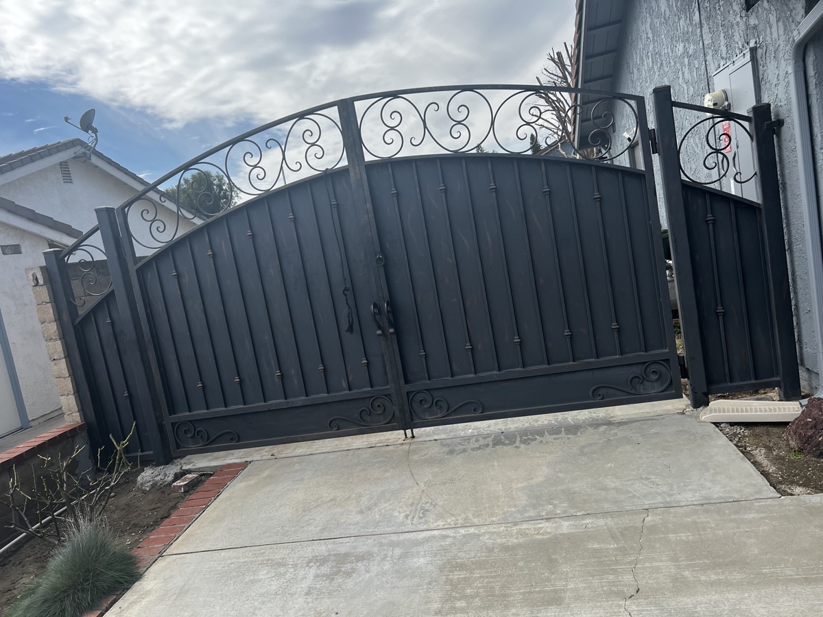 Ornamental iron driveway gate with scrollwork