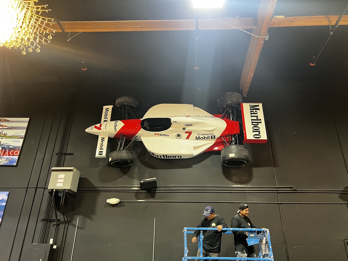 Legendary Metal Works team mounting F1 car on wall - custom metal fabrication in Ventura CA