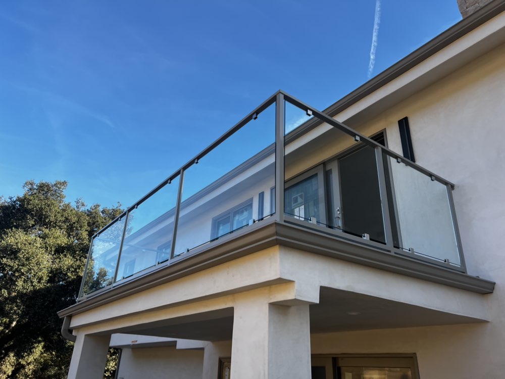 Glass balcony railing with steel frame on modern home by Legendary Metal Works